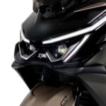 frotal de un scooter SYM Cruisym 400 marrón con las luces de día encendidas