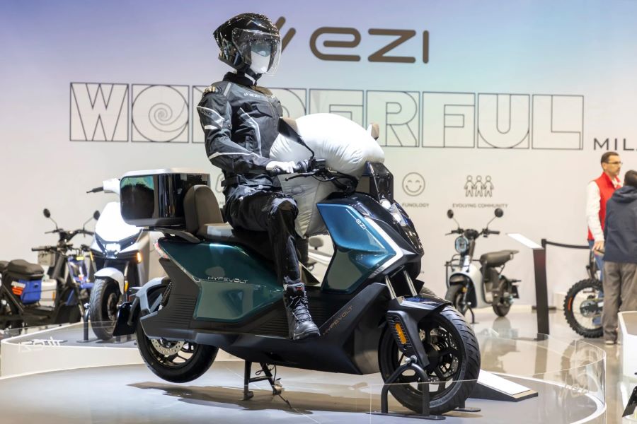 Ezi Hypervolt azul con el airbag inflado, exhibido en el stand de la marca en el Eicma 2025