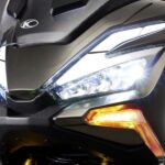 Parte frontal de un ascooter KYMCO X-Tera 350 con los faros encendidos