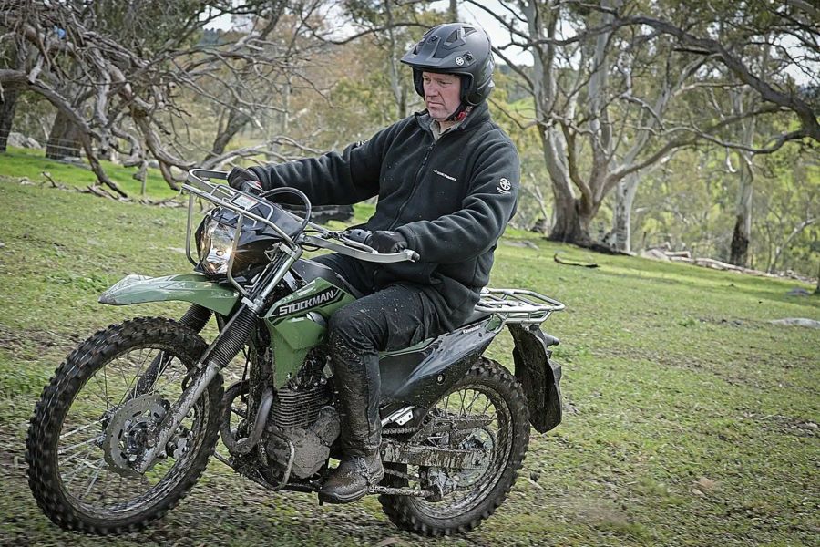 Un usuario se desplaza por el campo embarrado con una moto Kawasaki Stockman 