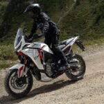 La Moto Morini X-CAPE 1200 obliga a dar explicaciones Una Moto Morini X-CAPE 1200 2026 blanca se desplaza por el ripio con su conductor parado sobre los pedalines