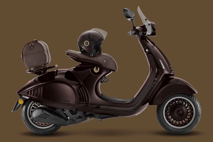 Vista lateral derecha de una Vespa 946 Horse con maleta de cuero sobre guardabarros trasero y un casco jet a tono sobre el asiento