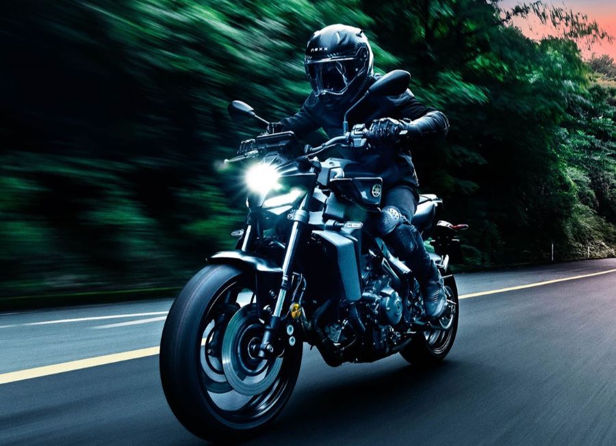 Una moto Yamaha MT-09 Y-AMT 2026 avanza con las luces encendidas por una ruta