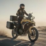 un moto ZXMoto 820X, conducida por una mujer, se desplaza a velocidad pura por un camino de tierra