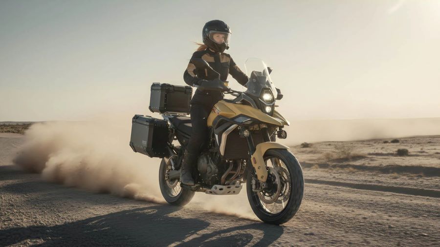 un moto ZXMoto 820X, conducida por una mujer, se desplaza a velocidad pura por un camino de tierra