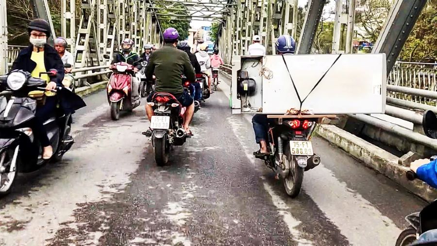 Varios motociclistas cruzan en ambas direcciones un puente en Vietnam