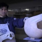 ¿Por qué los cascos Arai tienen forma de huevo? Un operario manipula un casco en proceso de fabricación en la sala de producción de Arai