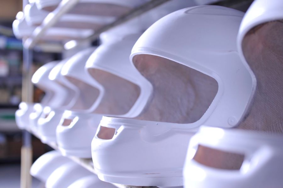 Una vistrina muestra una serie de cascos Arai blancos en proceso de producción