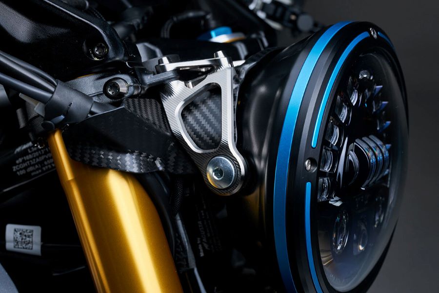 Primer plano de costado del faro delantero redondo y parcial de la horquilla de una moto MV Agusta Rush Titanio