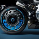 Rush Titanio: la MV Agusta pensada para no repetirse Medio lateral derecho trasero de una moto MV Agusta Rush Titanio, donde destacan motor, escape y poderosa rueda con llanta ciega en todo azul