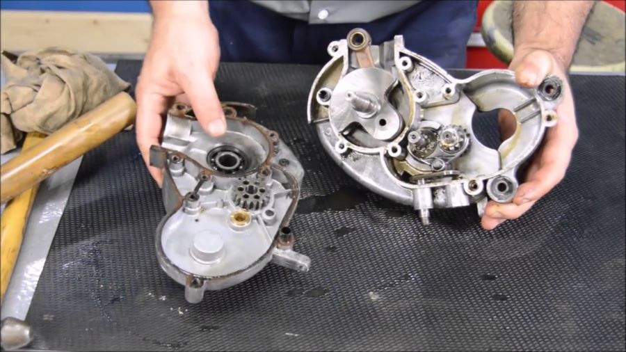 Cómo desarmar un motor de moto: guía completa principiantes Manos de un mecánico muestra una pieza abierta de un motor de moto