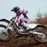 Un piloto derrapa en el barro con una moto Bimota BX450 blanca