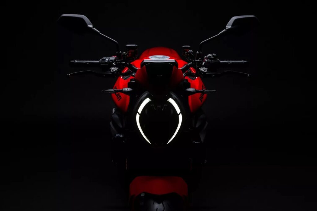 El fato delantero enncedido de una Ducati Monster 2026 roja en un contexto oscuro