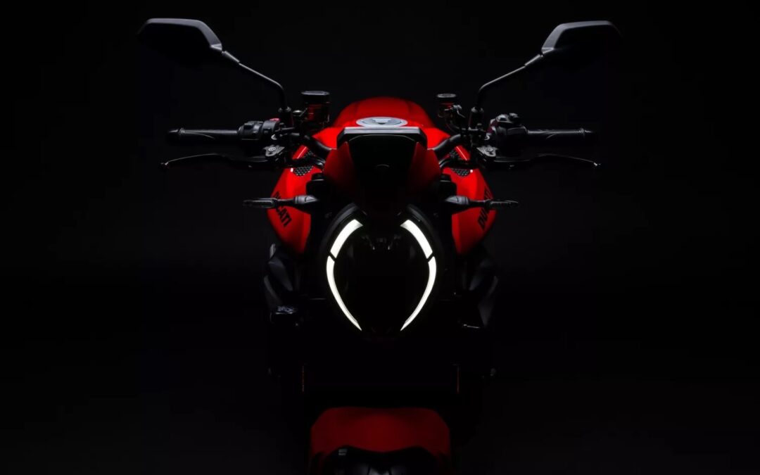 El fato delantero enncedido de una Ducati Monster 2026 roja en un contexto oscuro
