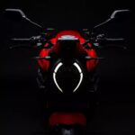 El fato delantero enncedido de una Ducati Monster 2026 roja en un contexto oscuro