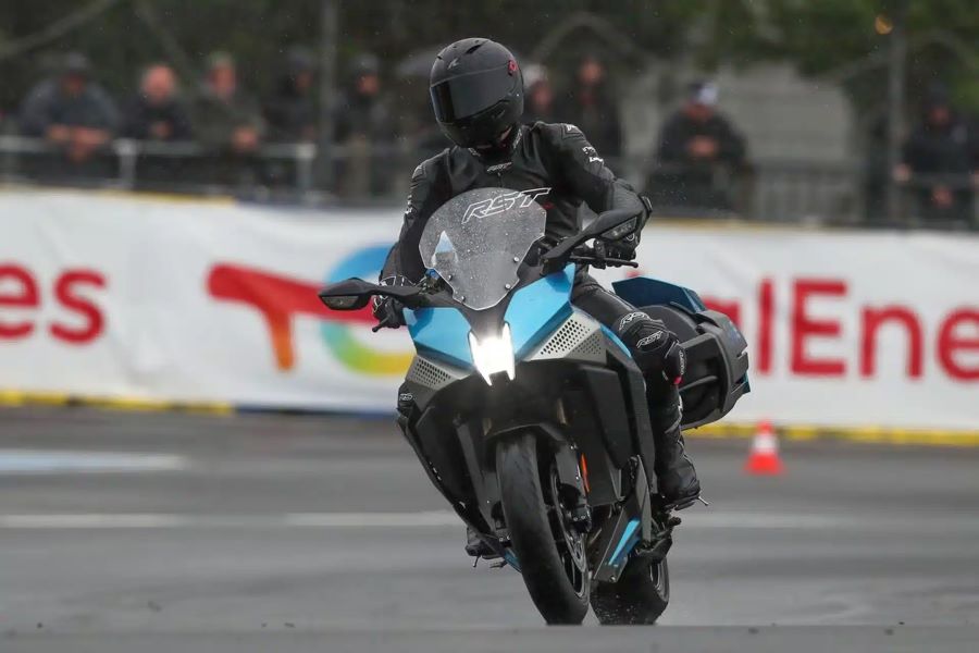 Una moto experimental Kawasaki HS HySE viene de frente con las luces encendidas