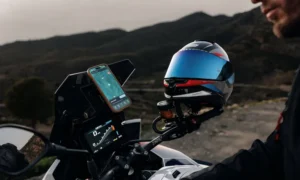 Un motociclista programa su navegador al casco Nolan X-904 Ultra Carbon apoyado en el espejo retrovisor de la moto