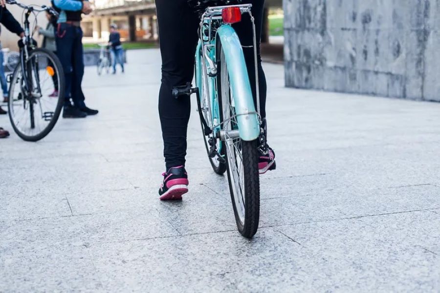 Una persona sobre una bicicleta celeste apoya pierna apoya en el suelo