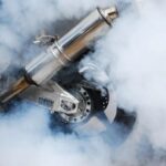Por qué una moto saca humo azul | Causas y posibles soluciones Rueda trasera de una moto apenas visible entre le humo