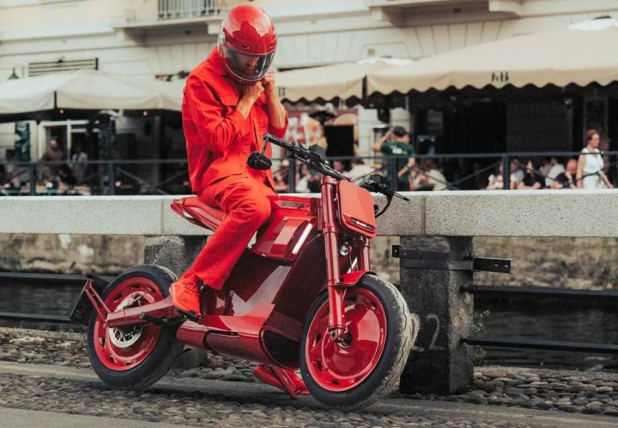 Un usuario vestido de rojo se abrocha el casco sentado sobre una moto Brabus Urban E Firts Edition