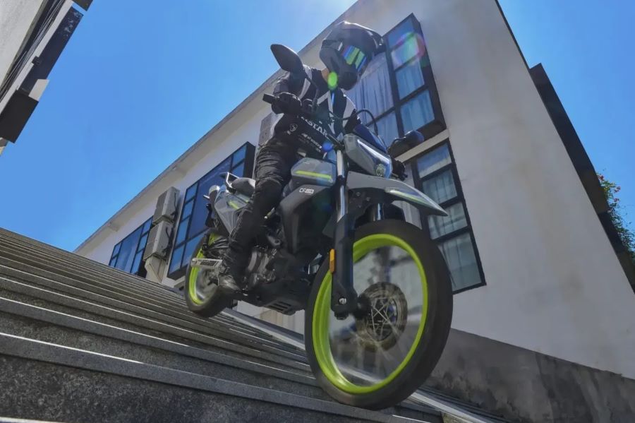 Un usuario de la CFLITE Dual 250 baja con su moto una escalera de cemento