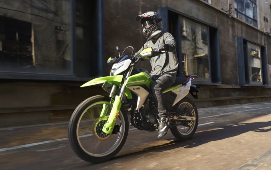 Una Moto CFLite 250 dual verde transita la ciudad