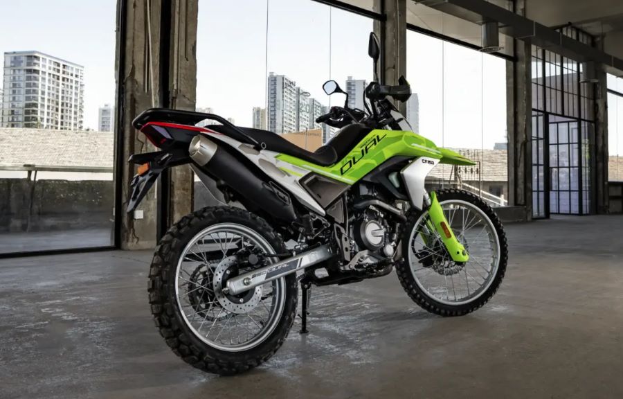 Una moto CFLITE Dual 250 verde posa en interior de una edificio con amplios ventanales