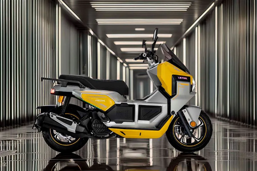 Lateral derecho de un scooter Letbe Mecha 125 amarillo con fondo de luces