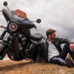 Un hombre con campera de cueroy jeans descansa apoyado en su Moto Morini Calibro Bagger