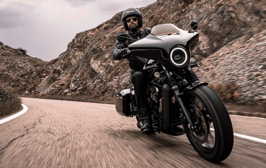 vista frontal de una moto Moto Morini Calibro Bagger que transita por una ruta montañosa