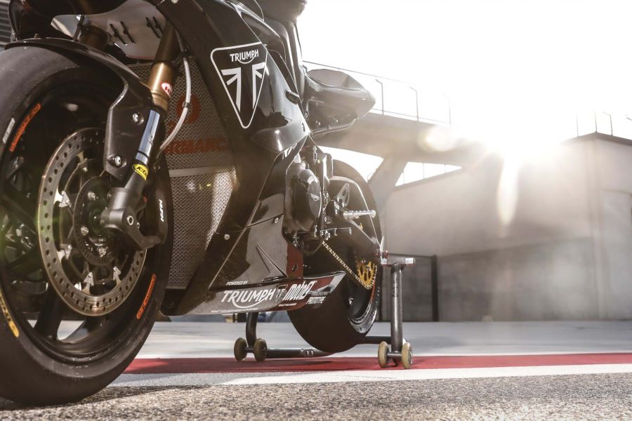 Una moto de Moto2 tomada desde abajo y con un sol de frente