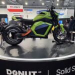 una moto Verge TS Pro posa sobre una plataforma circular en cuyo contorno se puede leer "Donut-solid state"