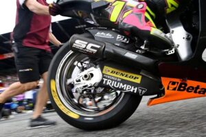 Vista parcial de un mecánico empujando una moto de Moto2