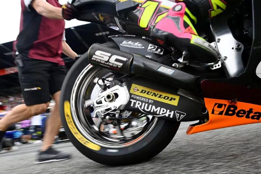 Vista parcial de un mecánico empujando una moto de Moto2
