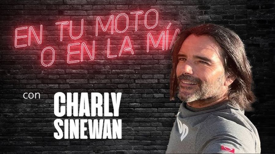 Charly Sinewan ¿Por qué es una referencia de viajes en moto? Charly sinewan posa delante de una leyenda escrita con letras de neón