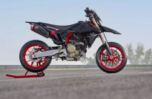vista lateral derecha de una Moto Ducati Supermotard negra con llantas rojas
