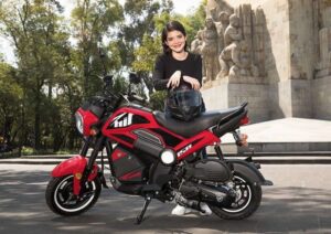 Una adolescente mira sonriente apoyada en su moto Italika BIT 150 roja