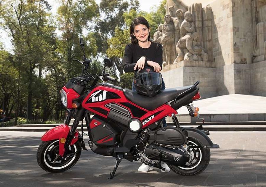 Una adolescente mira sonriente apoyada en su moto Italika BIT 150 roja