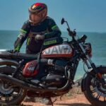 Un usuario de apoya sobre su moto Jawa 42FJ para observar el paisaje marino