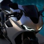 vista en perspectiva e una superbike británica Norton Manx R con la luces encendidas en un entorno oscuro