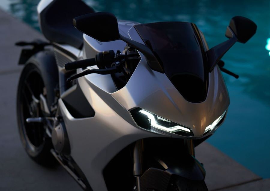 vista en perspectiva e una superbike británica Norton Manx R con la luces encendidas en un entorno oscuro