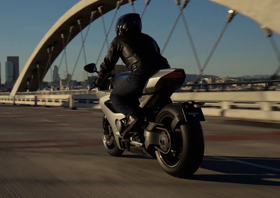 vista trasera de una superbike británica Norton Manx R circula por un puente