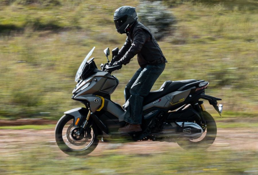 Un usuario de un scooter VOGE SR450X se para sobre las estriberas en pleno sendero de tierra
