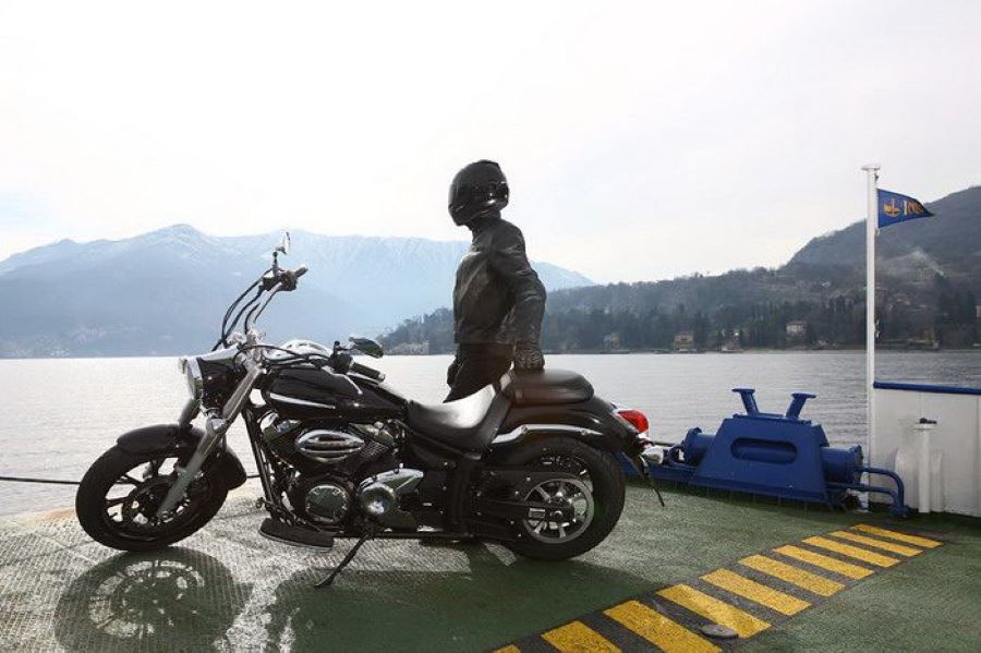 Mejores motos custom para viajar | Comparativa completa Un motociclista posa con casco al lado de una Yamaha V Star 950