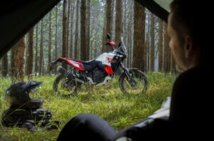 Un silueta de un hombre mira a distancia su Yamaha Ténéré World Raid 2026 parada en un bosque verde