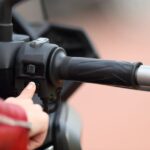 Mi moto no arranca en caliente | Causas comunes y soluciones una mano de mujer acciona el arranque electrónico de un moto