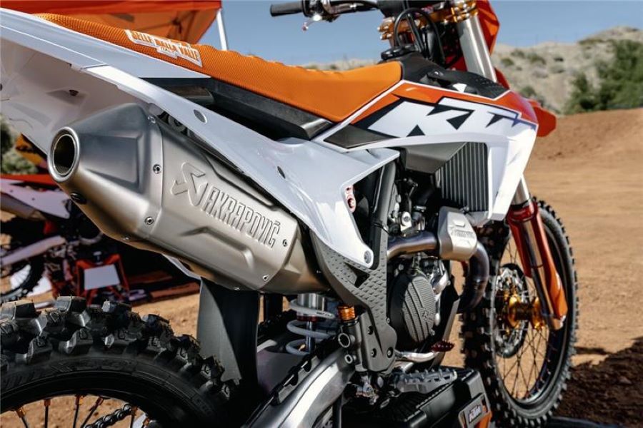En primer plano, una escape Acrapovic montado sobre una moto de motocross KTM