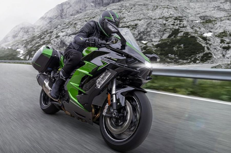 Una moto Kawasaki Ninja H2 SX SE viaja por una ruta montañosa