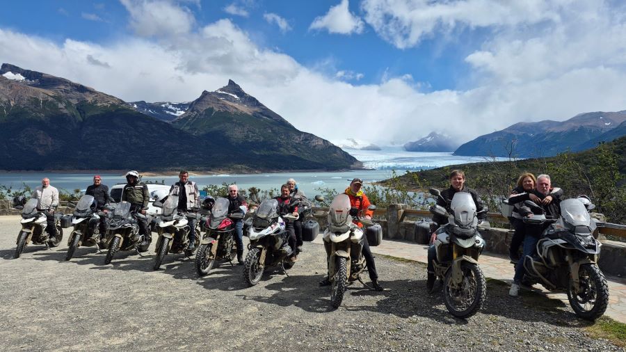 Un grupo de motoviajeros posan sobre sus motos alquiladas con un fondo títpico del sur argentino