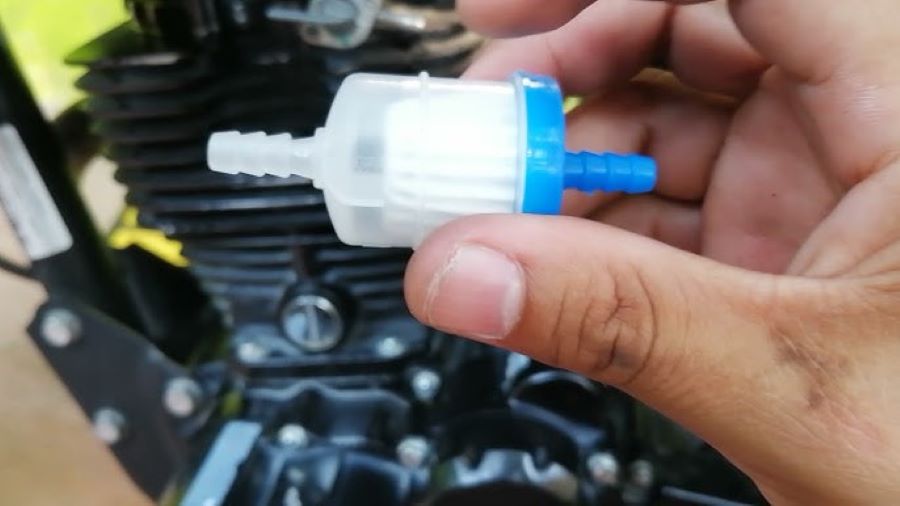 Una mano sostiene un filtro de gasolina de moto